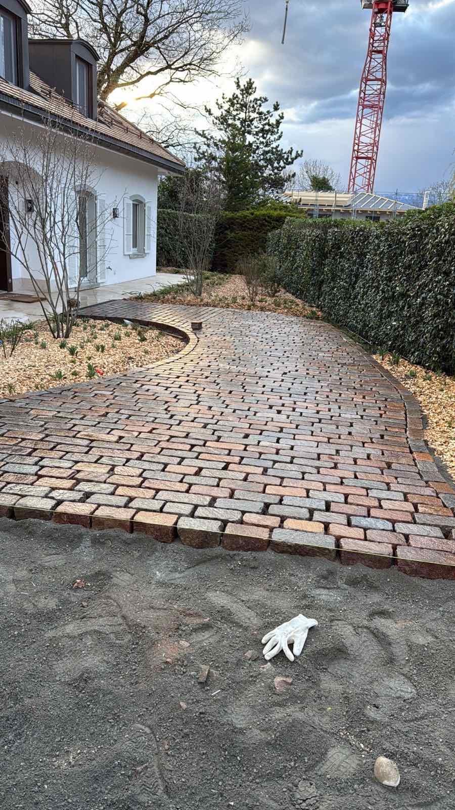 Cheminement courbe en pavés dans un aménagement paysager