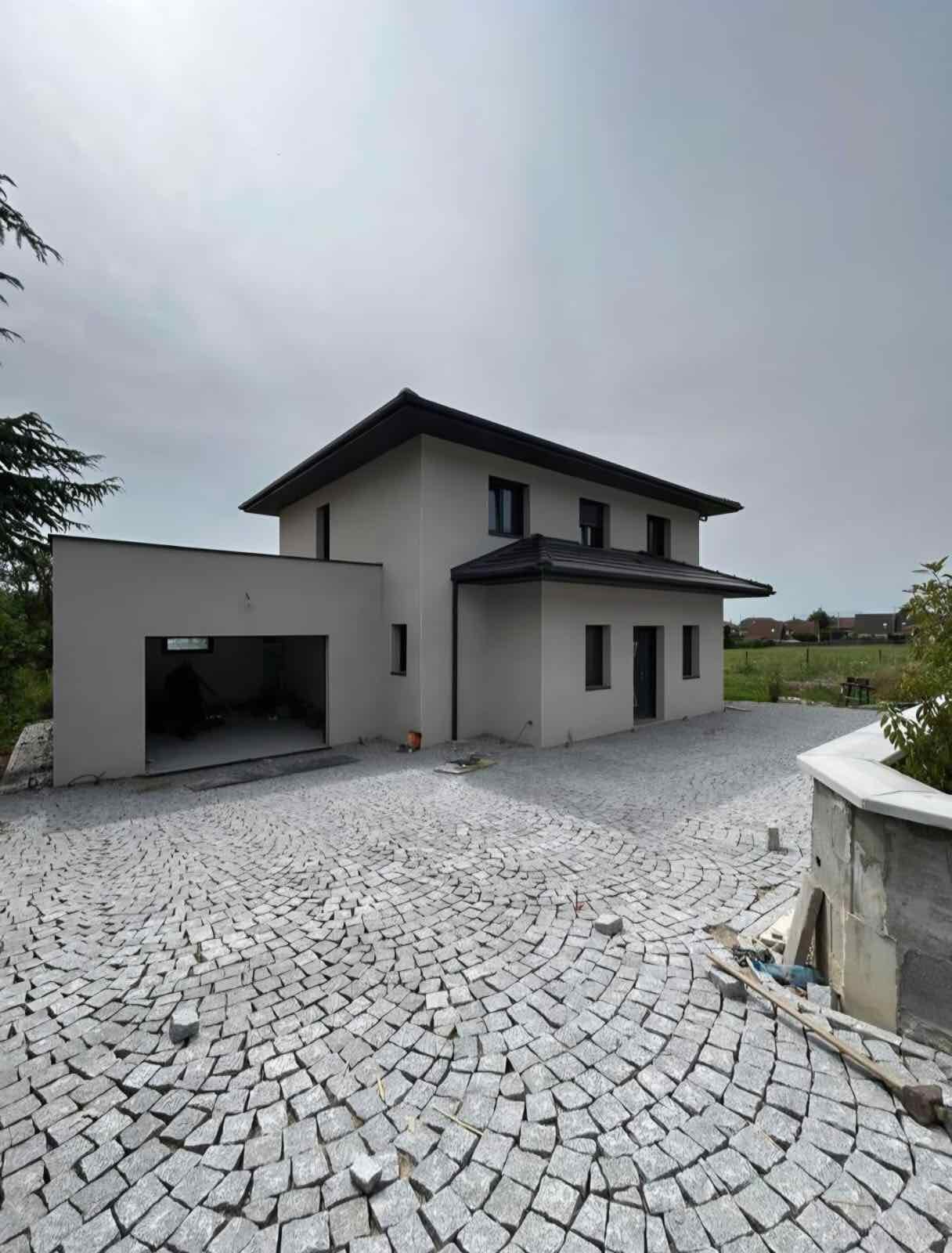 Cour résidentielle en pavés devant une maison neuve