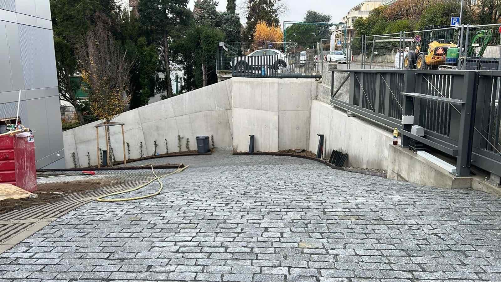 Rampe d'accès en pavés gris avec traitement de la pente